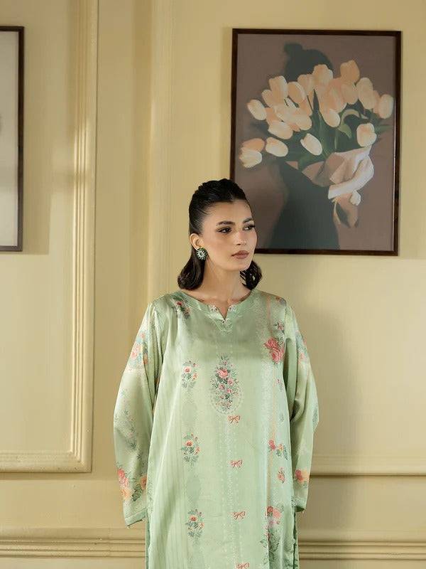 Women in light green silk 2-piece outfit with floral embroidery, indoor setting