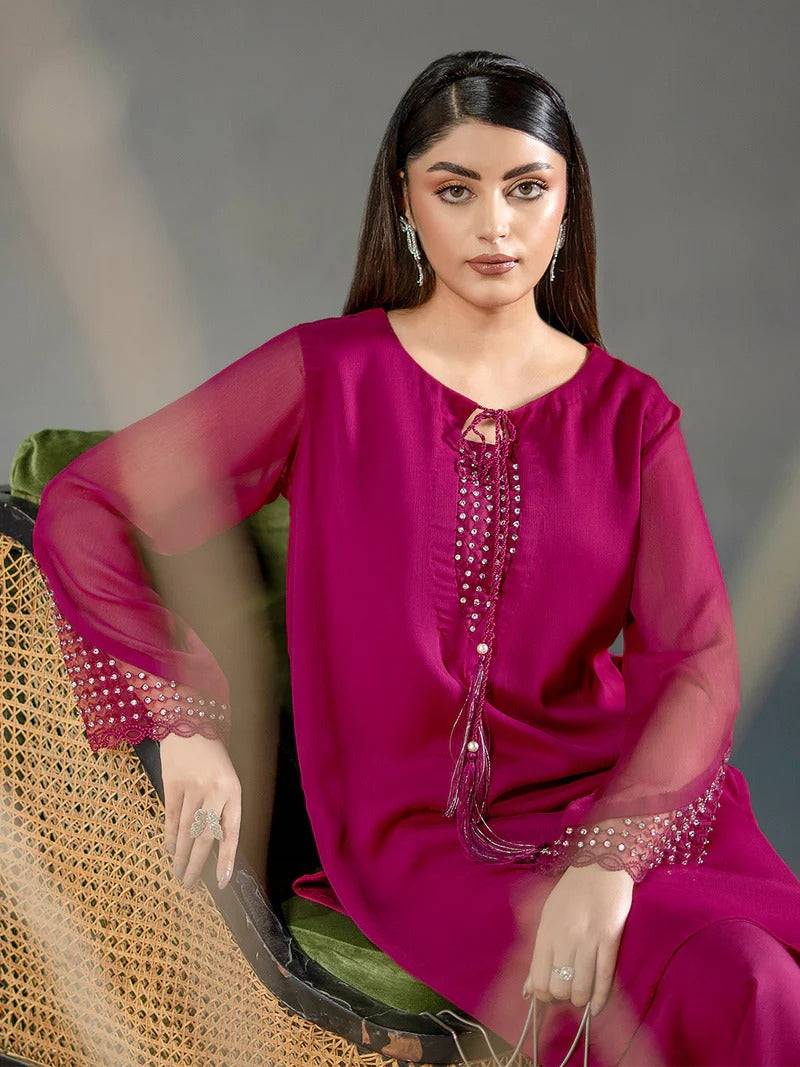 Close-up of magenta chiffon kurta with embroidered crystal neckline and sheer sleeves, styled with jewelry