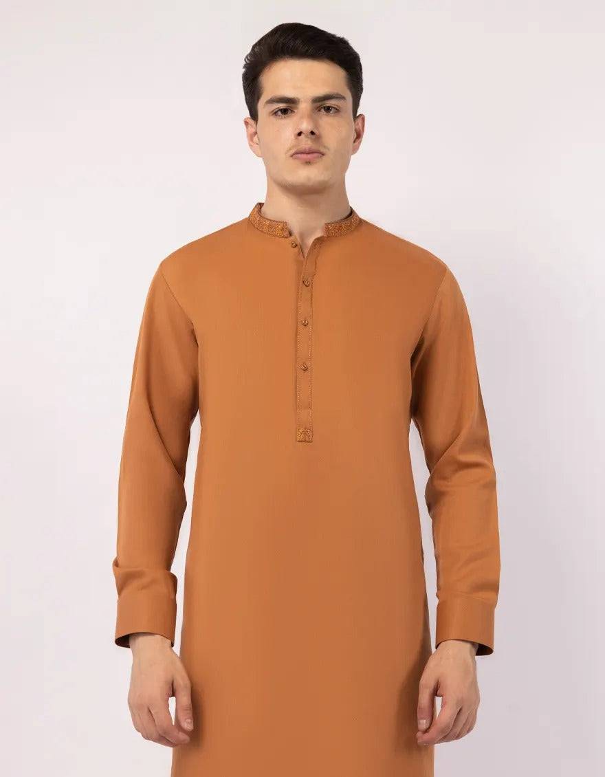 Close-up of orange kurta sleeve with button detail and embroidered cuff