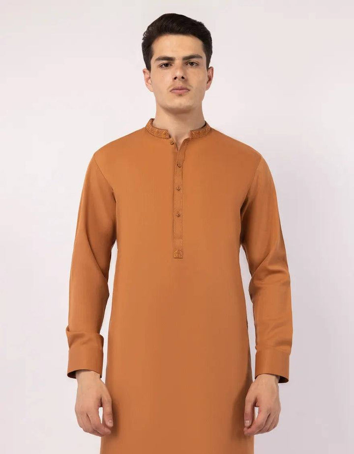 Close-up of orange kurta sleeve with button detail and embroidered cuff