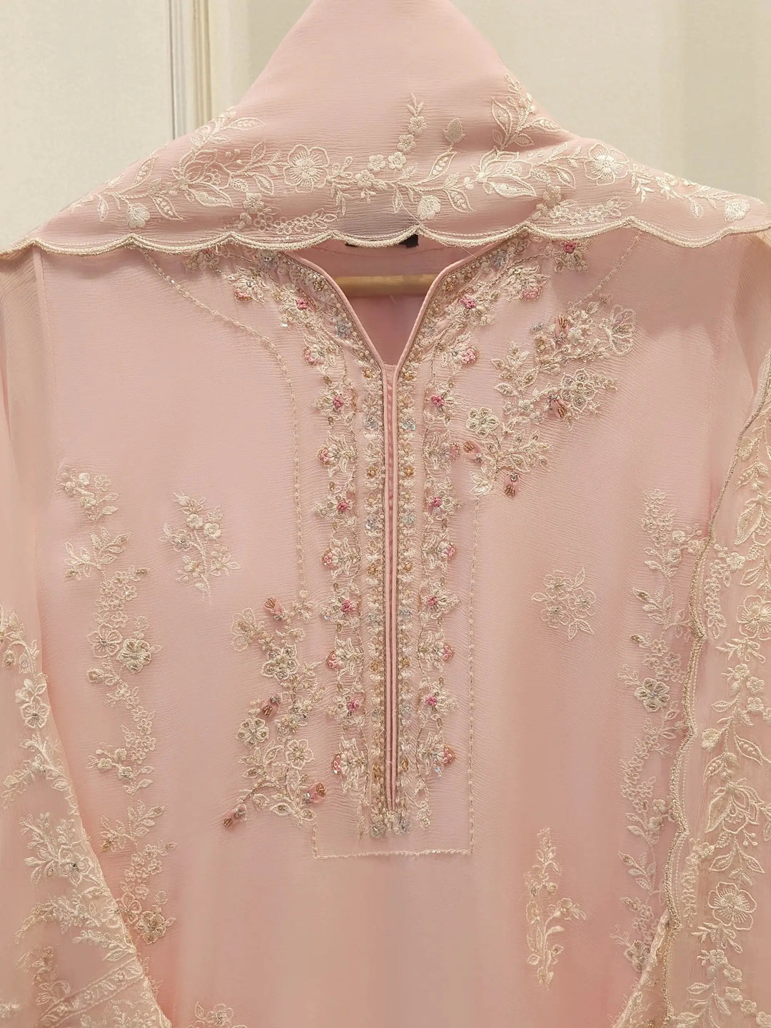 Close-up of AGHA NOOR Embroidered Chiffon Suit neckline with detailed floral embroidery and beadwork on soft pink chiffon fabric.