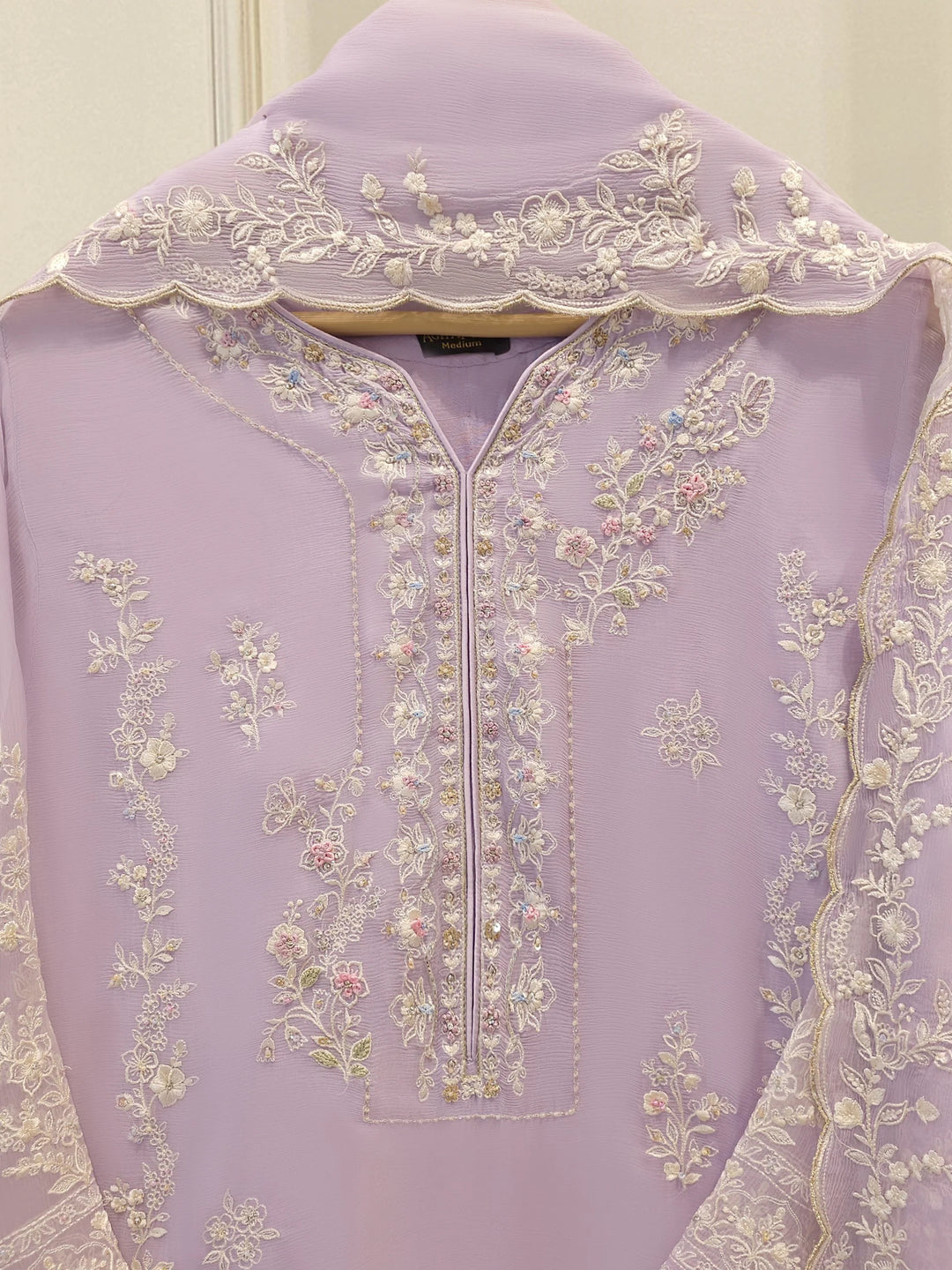 Front neckline detail of AGHA NOOR Embroidered Chiffon Suit with pastel floral embroidery and embellished placket design.