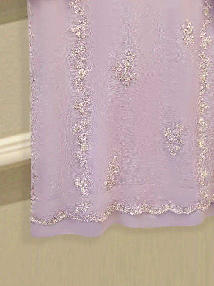 Lower portion of AGHA NOOR Chiffon Shirt with vertical floral embroidery and scalloped border on soft lilac fabric.