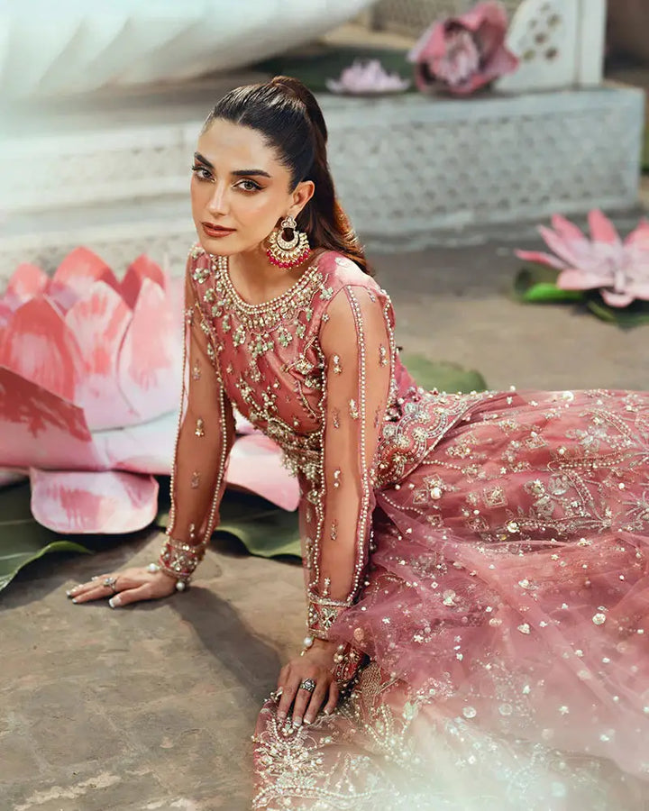 Close-up seated view of AR-142 ZORA coral pink wedding dress showcasing 3D floral embroidery and net fabric with pearl accents.