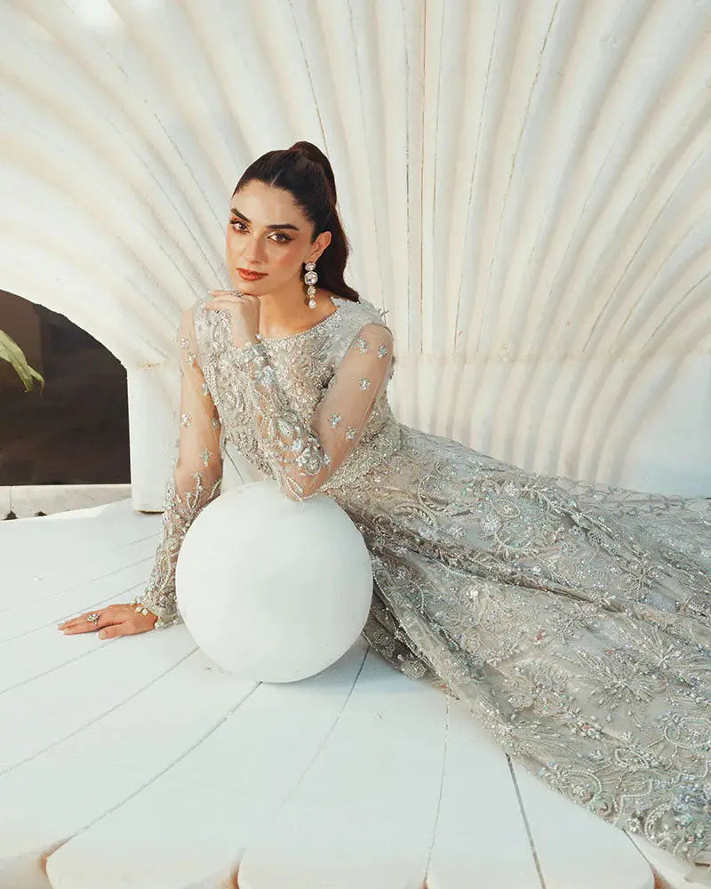 Model reclining in Formal Wear Crystal AR-138 Pakistani dress, highlighting the luxurious net and organza fabric with crystal embellishments.