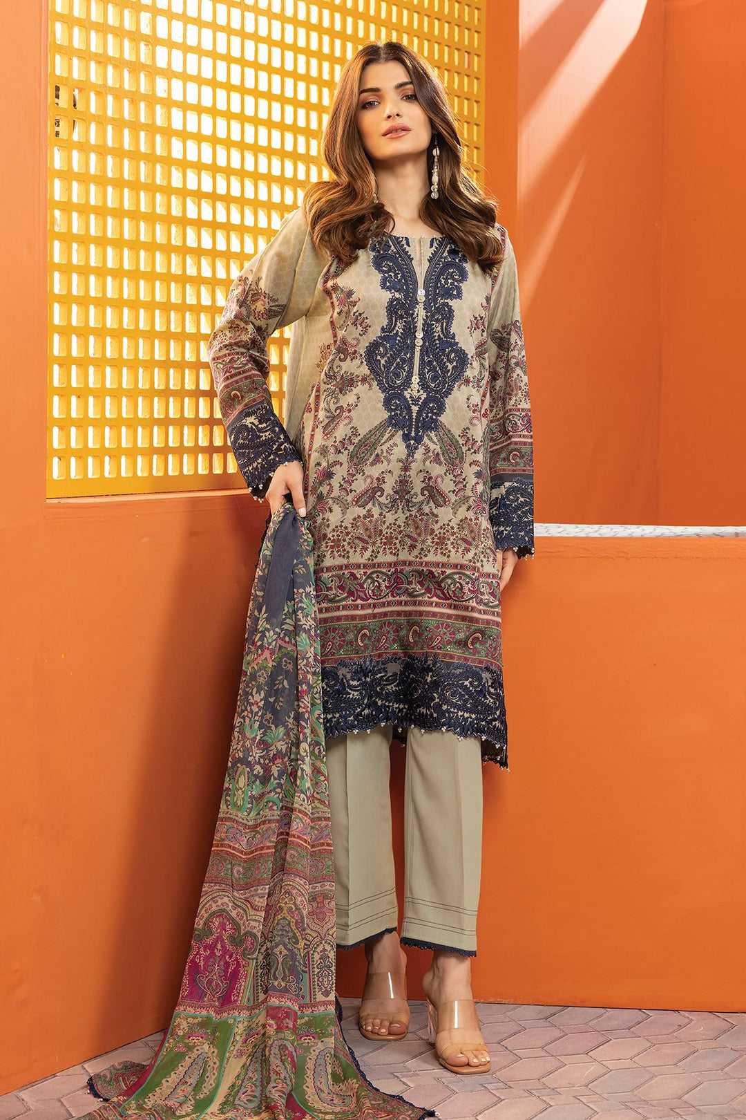 pakistani brands clothing a woman standing in front of an orange wall
