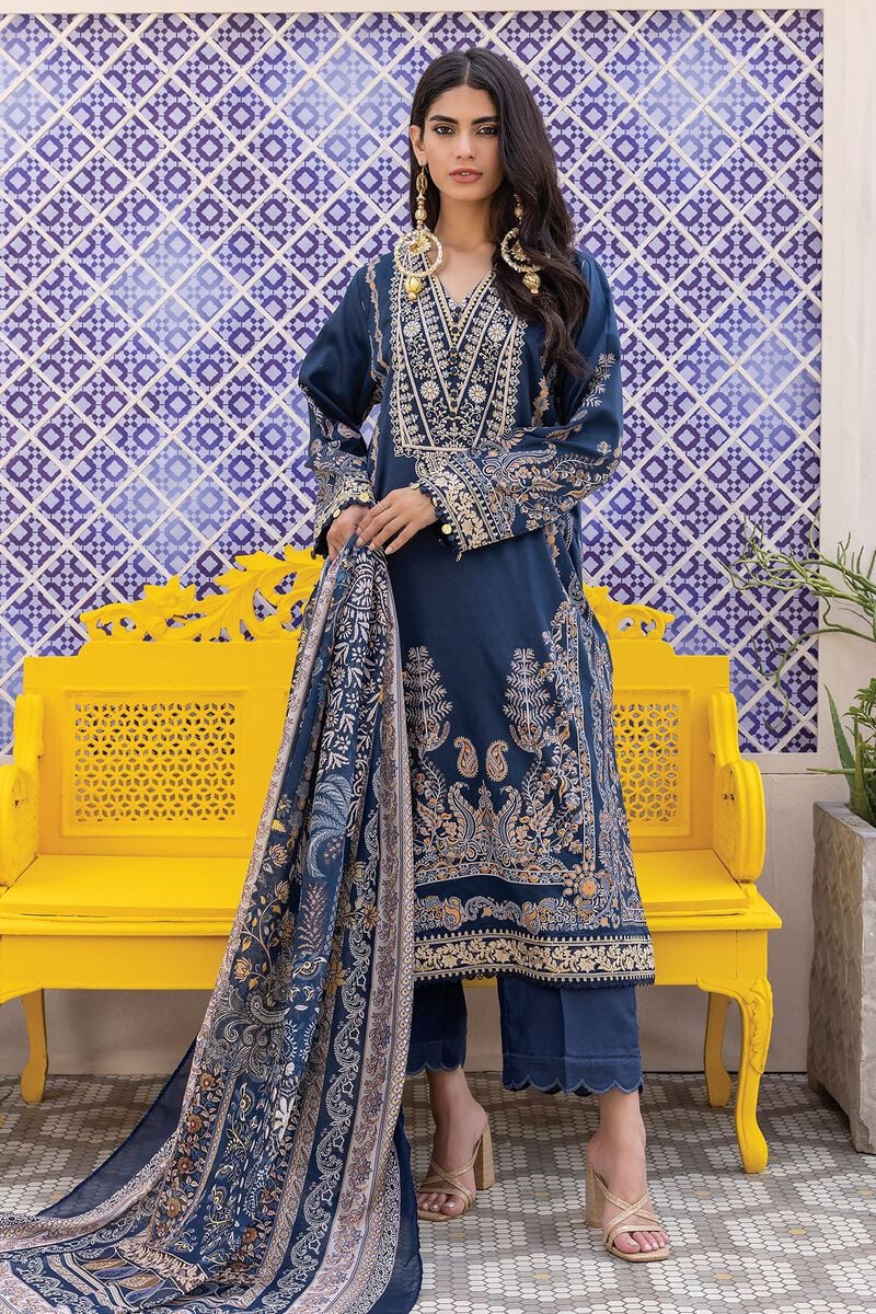 pakistani clothes online a woman in a blue dress standing in front of a yellow bench