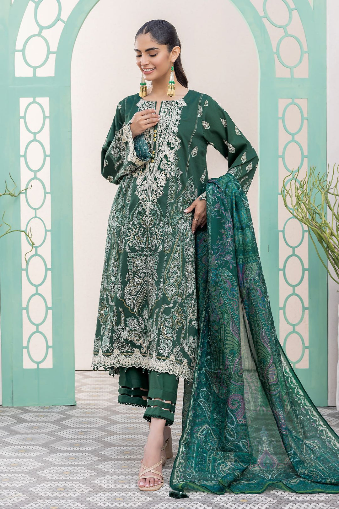 pakistani casual clothes a woman in a green dress standing in front of a wall