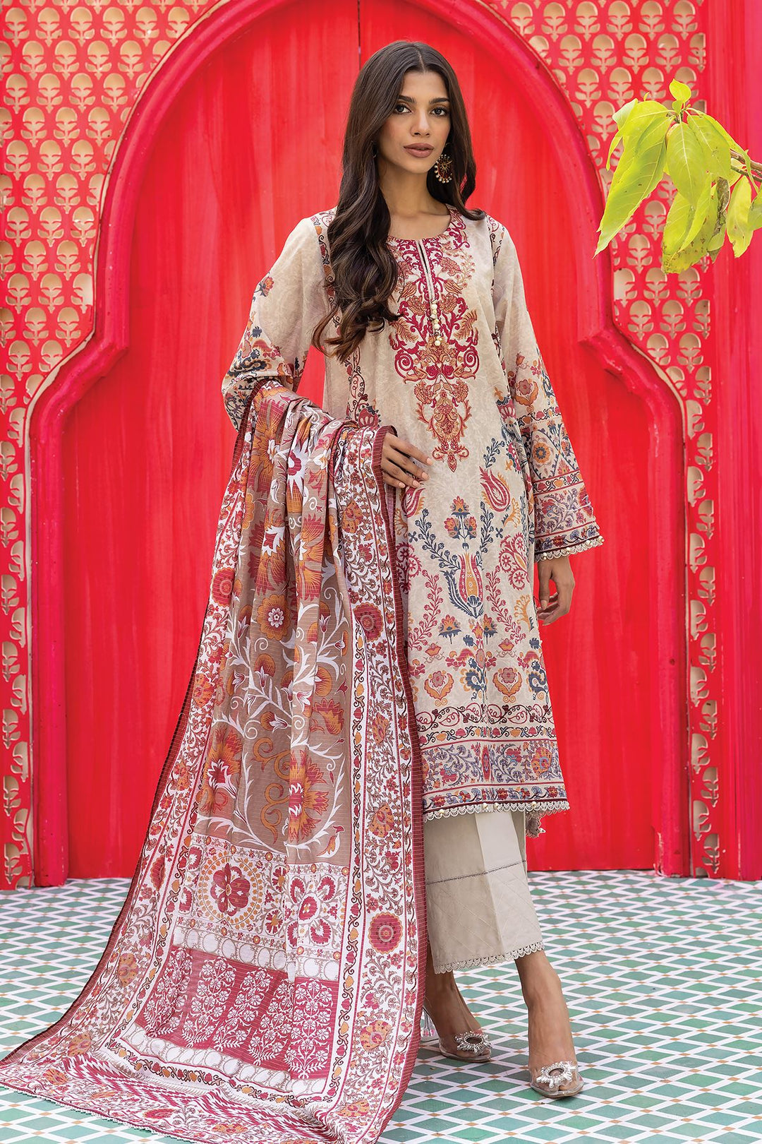 Pakistani outfits a woman in a white and red dress standing in front of a red wall