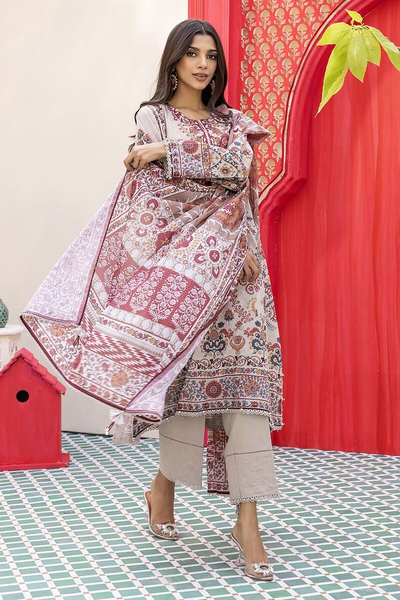 Pakistani outfits a woman standing in front of a red wall