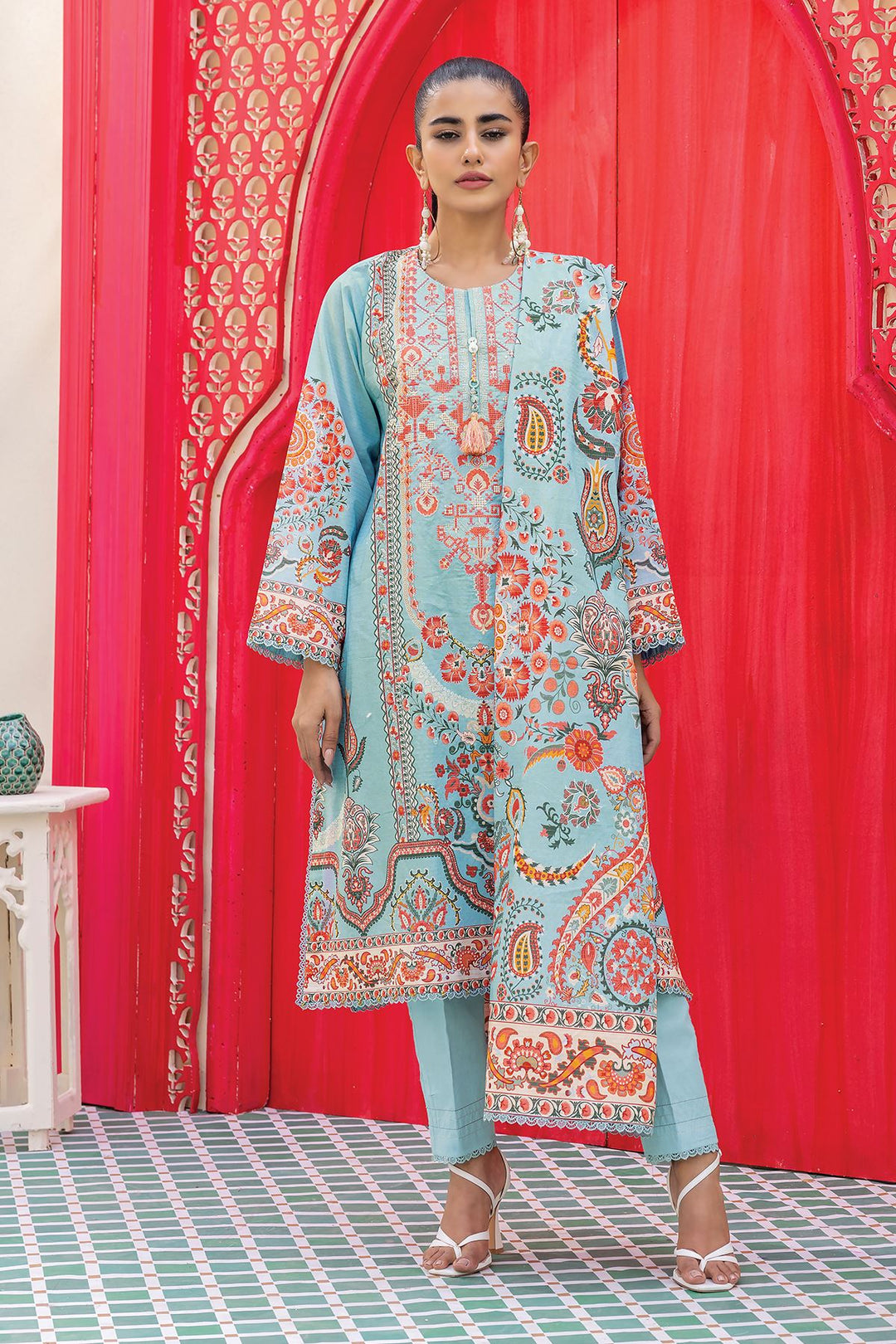 Online Pakistani Clothes a woman standing in front of a red wall