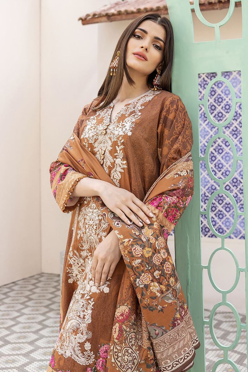 pakistani suits online a woman leaning against a wall wearing a brown dress