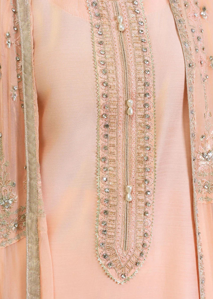 Front neckline detail of peach Pakistan gown dress woman with pearl and sequin embroidery, elegant and refined.