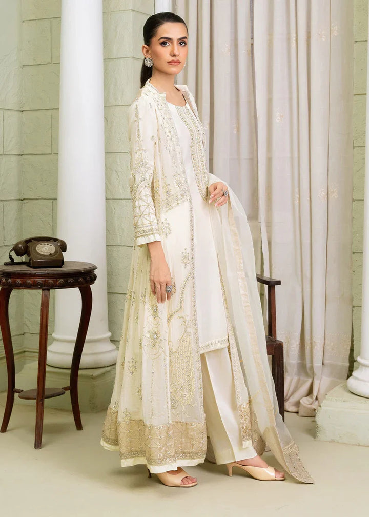Side profile of woman in ivory Pakistan gown dress with gold embroidery, shirt pants and dupatta for formal occasions.