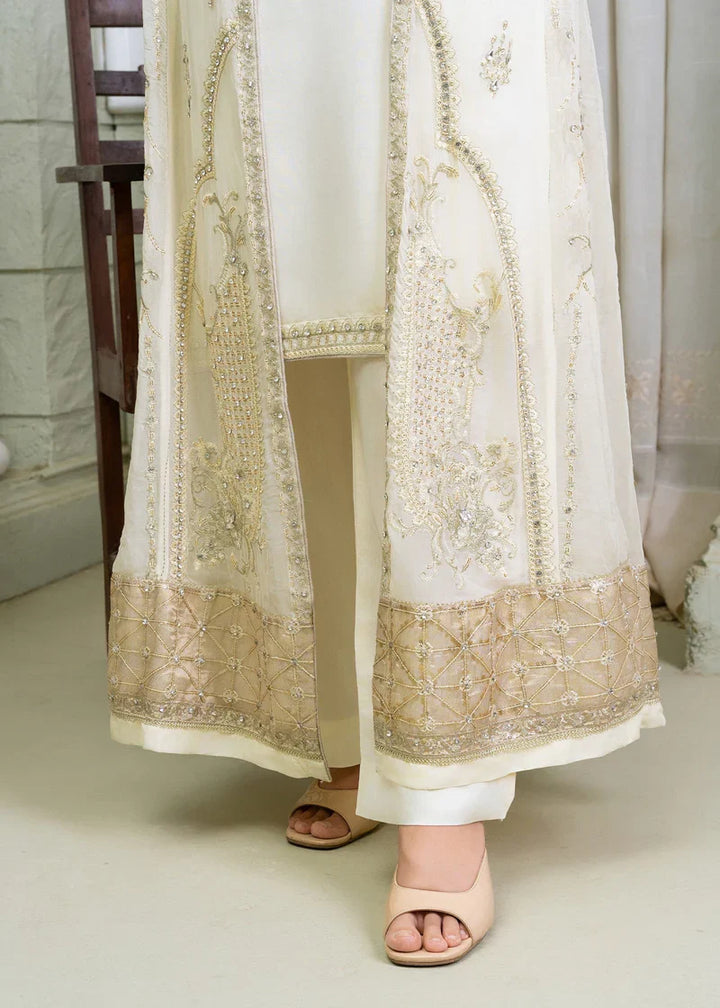 Close-up of ivory Pakistan gown dress hem with gold embroidery and embellishments, part of shirt pants and dupatta set for women.