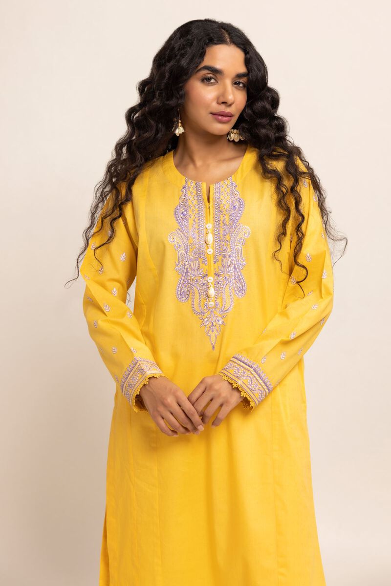 Authentic Pakistani Clothes Online a woman in a yellow dress with long curly hair
