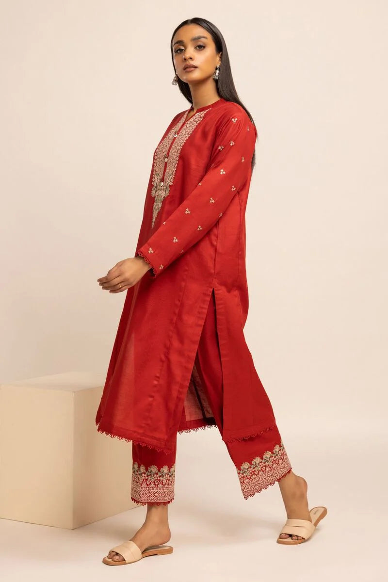 Khaadi USA pakistani suits online  a woman in a red outfit standing on a block