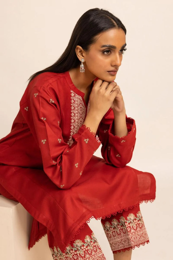 Khaadi USA pakistani suits online  a woman in a red dress sitting on a white bench