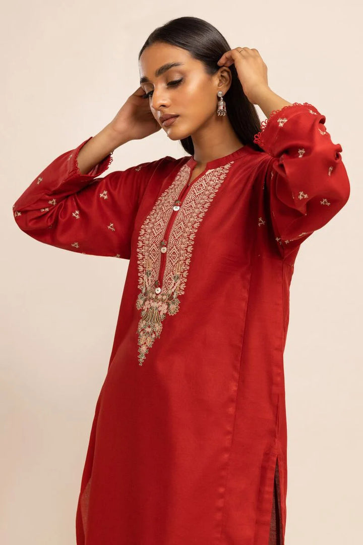 Khaadi USA pakistani suits online  a woman wearing a red dress with a gold embroidered design