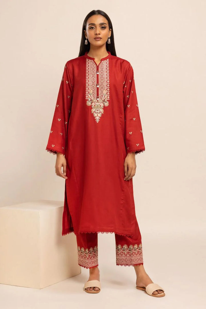 Khaadi USA pakistani suits online  a woman in a red dress standing next to a white block