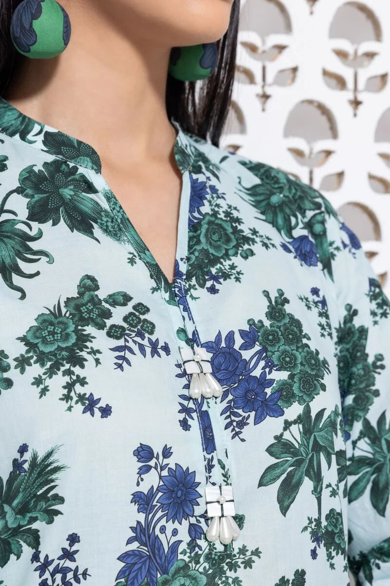 a khaadi  woman wearing green earrings and a blue shirt