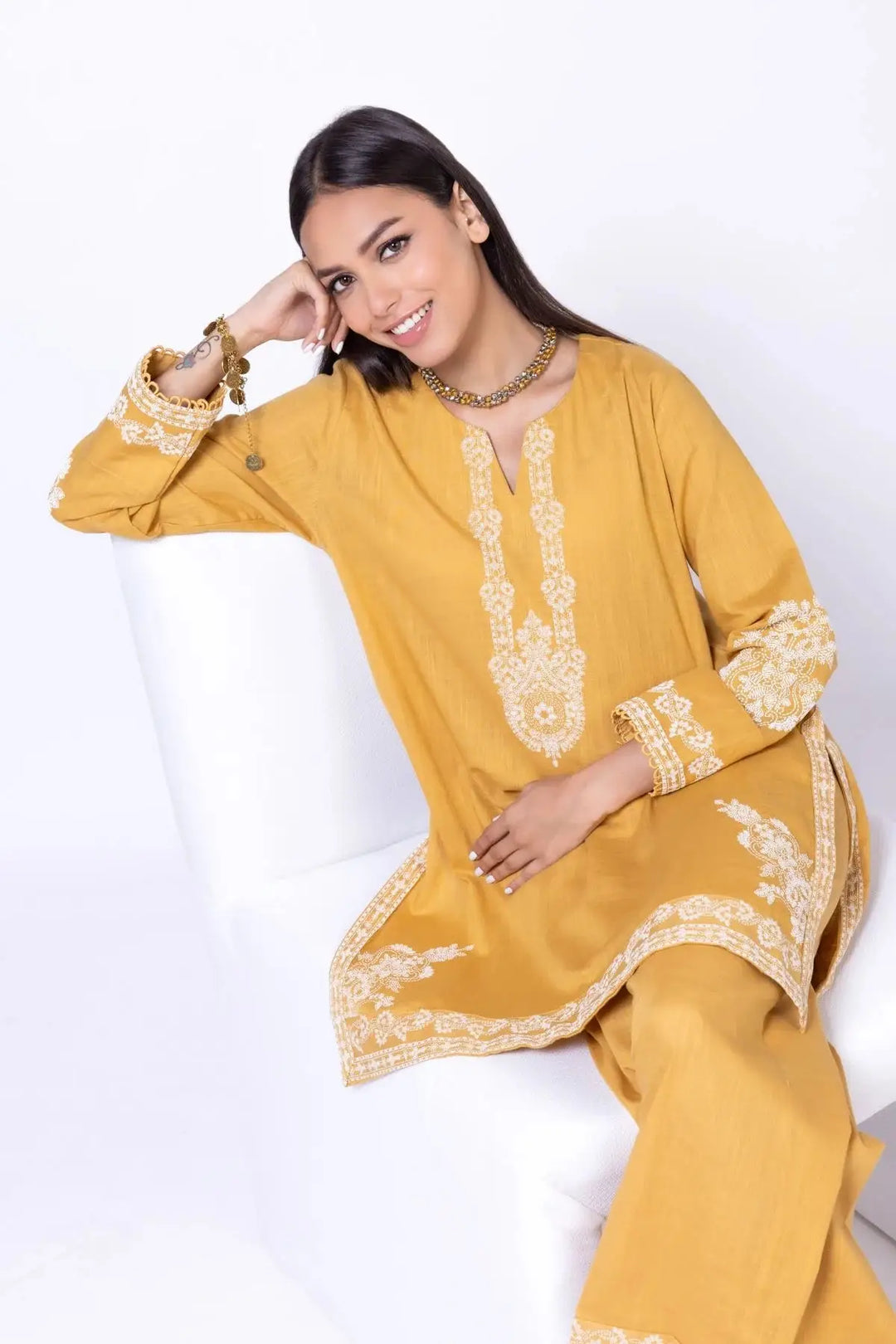 KHAADI 2P EET24701B mustard yellow traditional outfit with intricate white embroidery, featuring a long kurta and matching trousers.