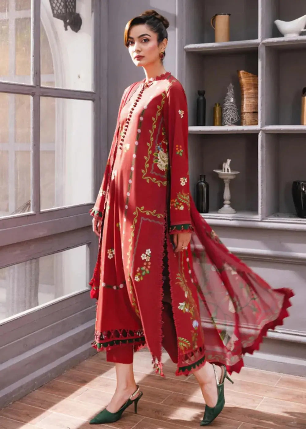 Side profile of MB-CUS25-1105-A stitched winter suit by Maria.B with red floral shirt, matching trousers, and flowing chiffon dupatta.