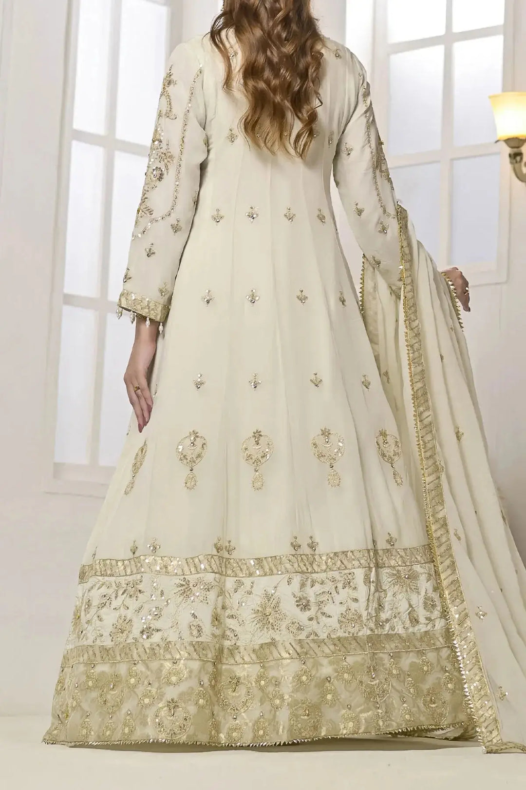 Back view of Rafia Chiffon Dress highlighting gold embroidered motifs and wide embellished hemline for special occasions.