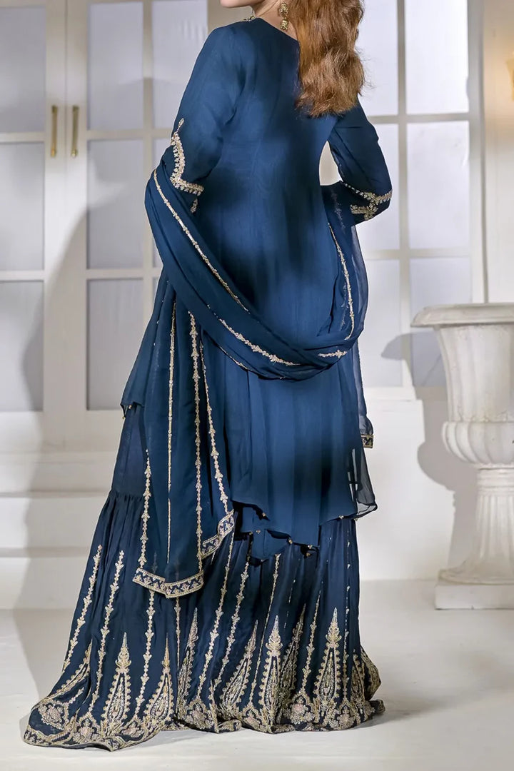Back view of Rafia Chiffon N2429 zinc-blue formal outfit featuring embroidered gharara and dupatta, ideal for Pakistani women's festive wear.