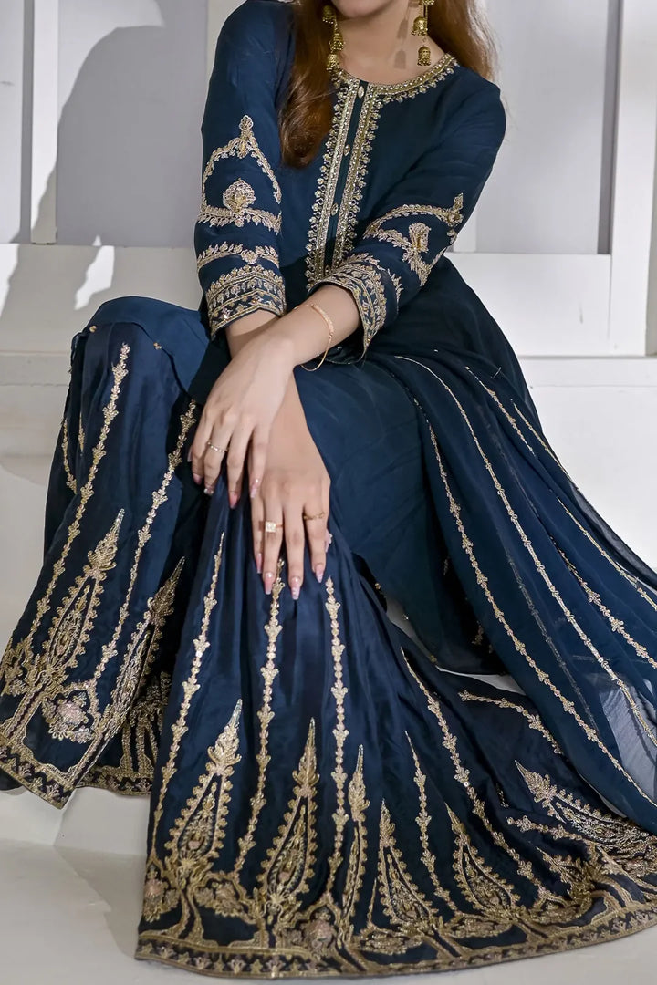 Close-up of Rafia Chiffon N2429 showcasing detailed embroidery on zinc-blue gharara and shirt, perfect for formal Pakistani occasions.