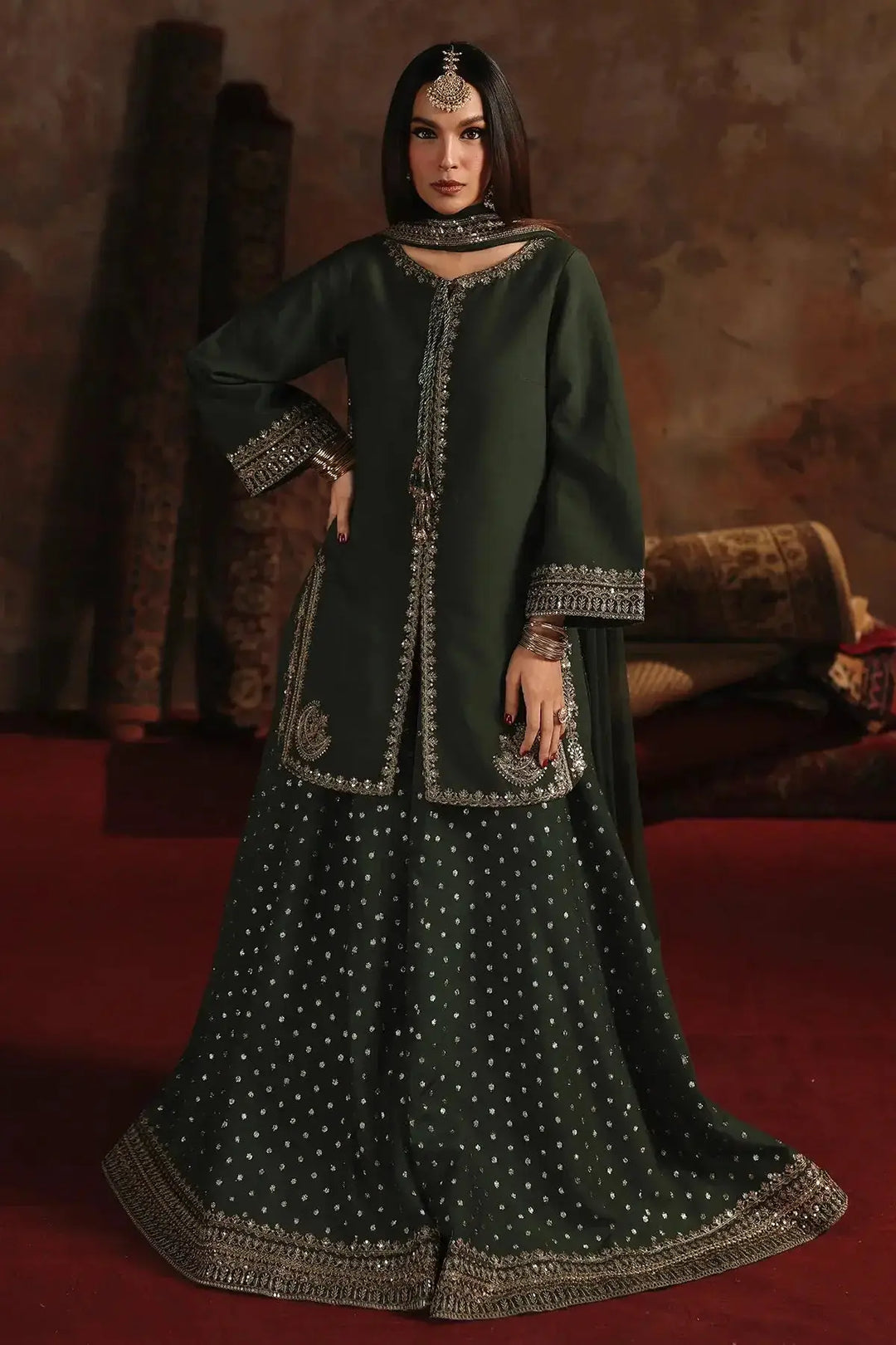 Elegant dark green embroidered raw-silk suit with intricate silver embellishments, matching shirt, bottom, and dupatta, styled for formal occasions
