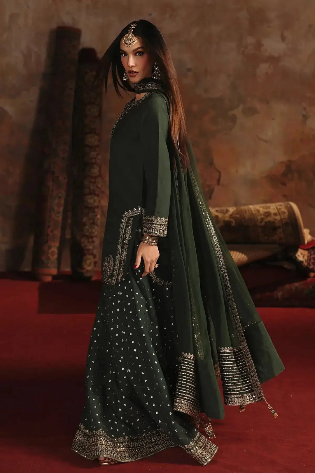Stylish dark green embroidered raw-silk suit with silver embroidery, complemented by traditional jewelry, perfect for festive or wedding events