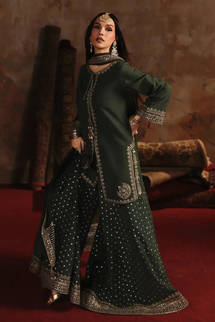 Model in deep emerald green embroidered raw-silk suit with silver accents, styled with jewelry, highlighting the elegant craftsmanship and fabric