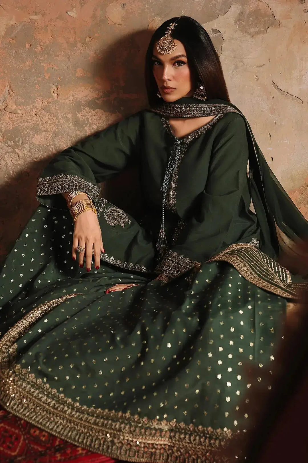 Embroidered raw-silk suit with gold accents and traditional jewelry