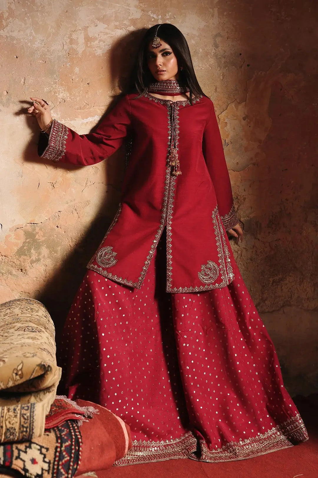 Red embroidered raw-silk suit with intricate gold embellishments and wide-leg pants