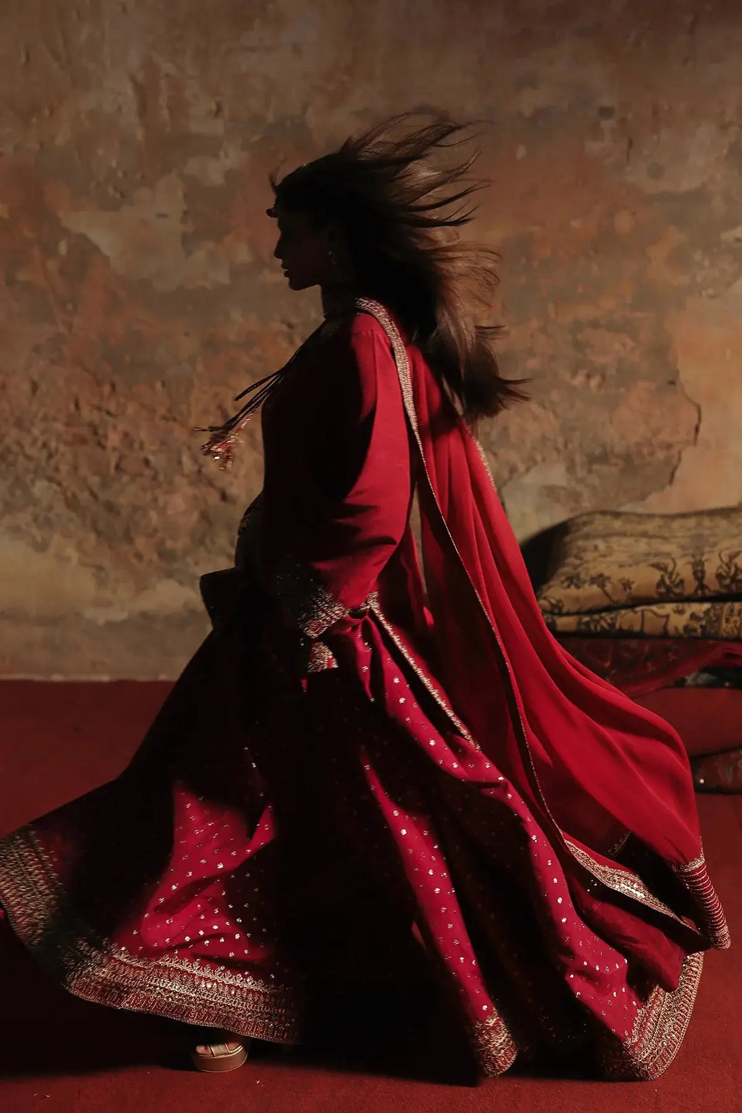 Model in red embroidered traditional outfit with flowing dupatta and detailed border