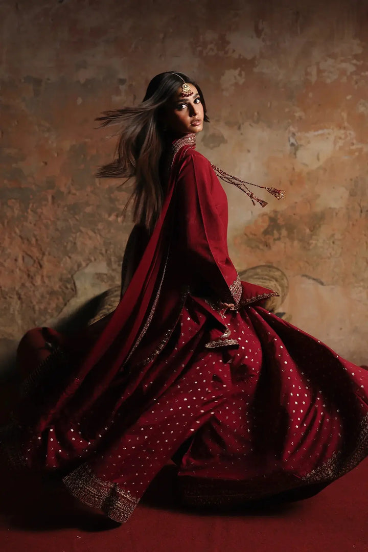 Close-up of model wearing red embroidered suit with ornate jewelry and flowing dupatta